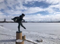 Eine Skulptur steht in einer schneebedeckten Landschaft.